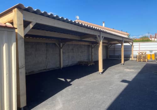 Photographie d'une charpente bois d'un abris avec une toiture tuile.